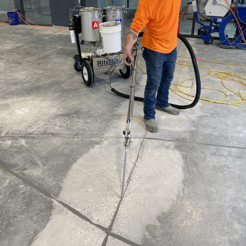 Worker using the AST GMP-50 to fill in cracks at the job site.