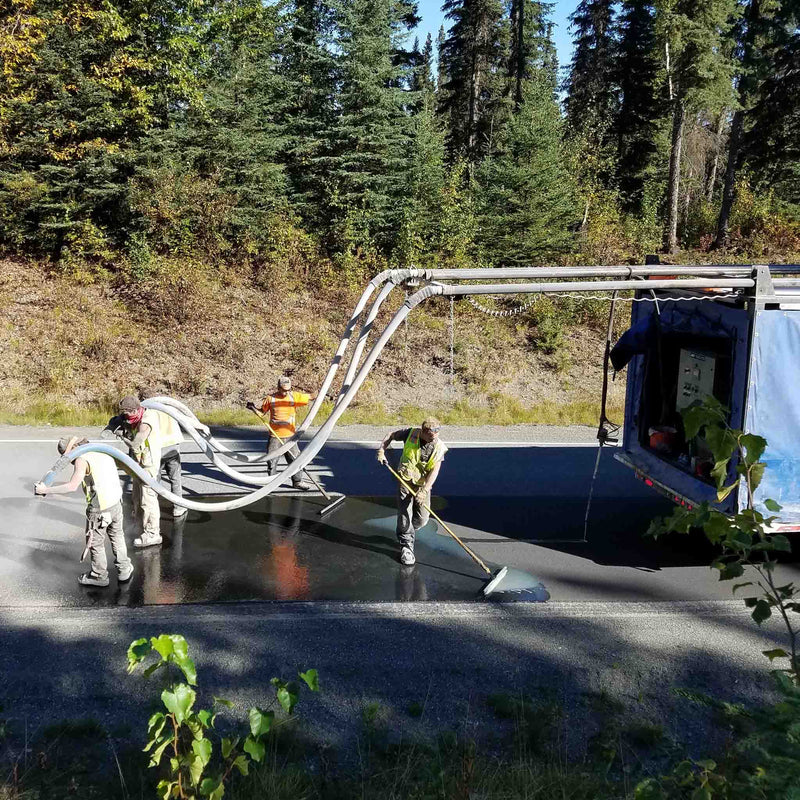 Workers coating the road using the AST GMP 500 dispensing system