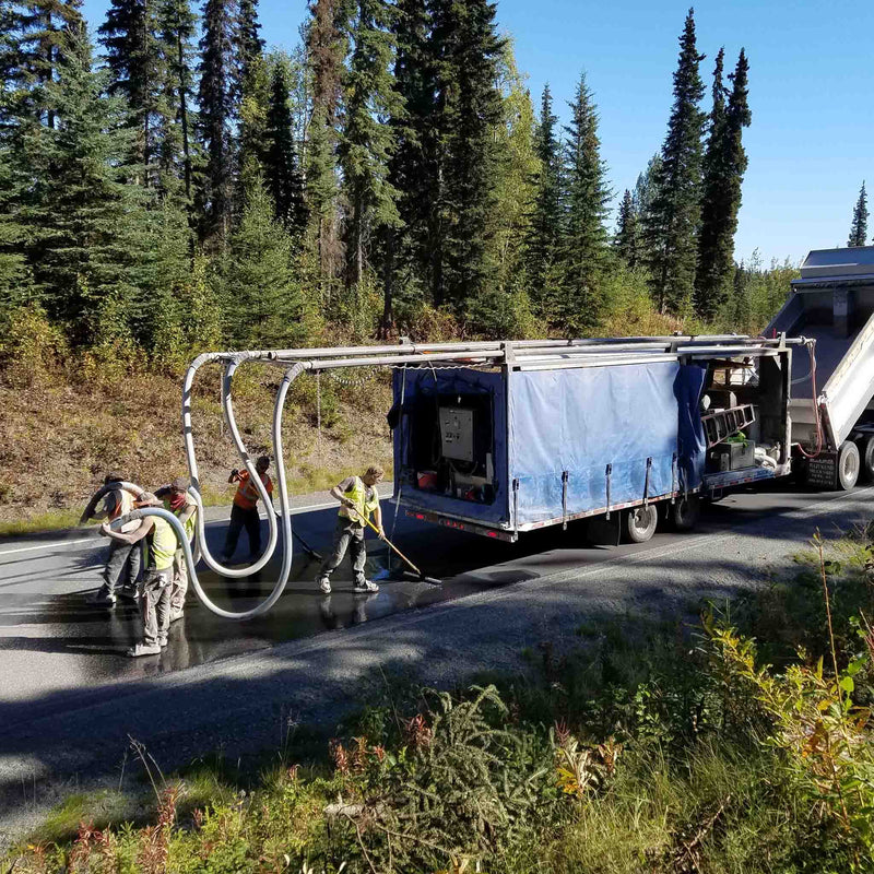 Workers coating the road using the AST GMP 500 dispensing system