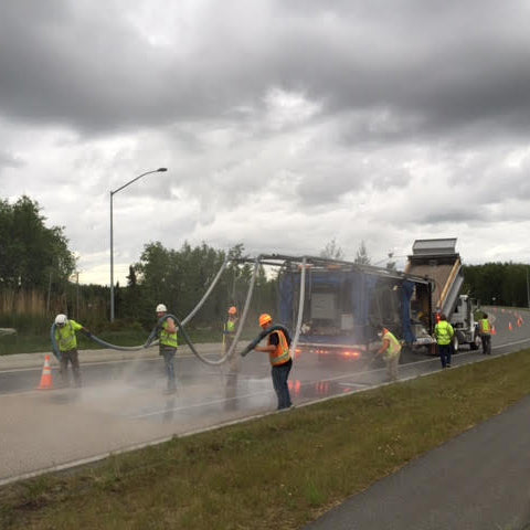 AST GMP 500 Road Overlay Dispensing System spraying a road