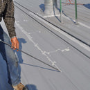 Worker using single component pail pump dispensing system to fill seams on the roof.