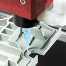 Close-up of a dispensing valve applying material onto plastic components with accuracy and consistency